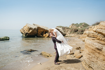 Newlyweds walk along the shore