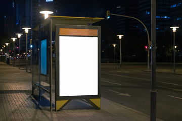 Blank space for advertisement at a bus stop. Lightbox mock-up at night. Horizontal.