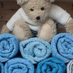 Fototapeta na wymiar ours en peluche sur serviettes de toilettes roulées