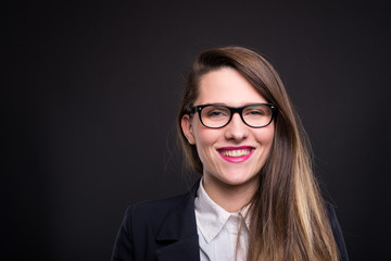 Smiling female manager posing on dark background