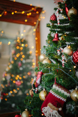 reflection of the lights from tree in the mirror the tree is decorated with toys