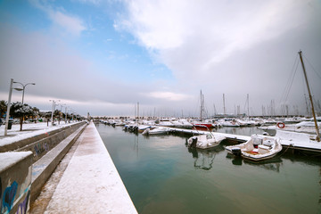 Fototapeta premium Ships and boats covered with snow in the port of the spanish town Denia