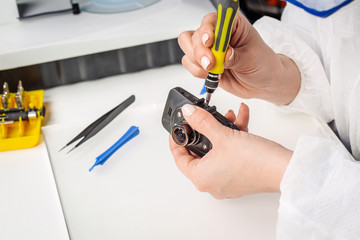 Close up hands of a service worker repairing Car DVR Front camera recorder.