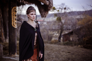 Viking woman with sword in a traditional warrior clothes.