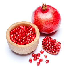 Pomegranate and seeds in wooden bowl close-up