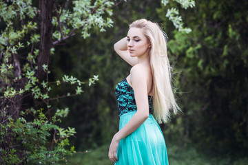 Naklejka premium Princess. Young beautiful pretty woman posing in long evening luxury dress on a sunny summer day. Vogue style fashion sensual portrait