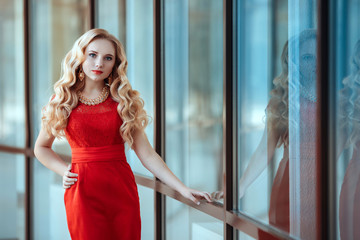 Fototapeta na wymiar portrait of stylish beautiful girl wearing short red dress posing or walking at the street