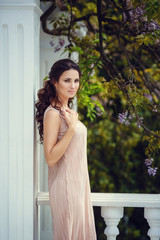 Fototapeta premium fashion outdoor photo of gorgeous woman with dark hair in elegant pink dress posing at summer park