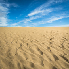 Fototapeta na wymiar Sand in the Dunes of Maspalomas, a small desert on Gran Canaria, Spain. Sand and sky.