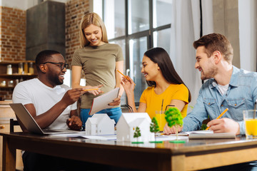 Materials improvement. Four inspired creative pensive students discussing mistakes while deciding how to correct them