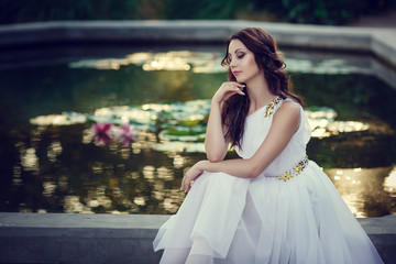 Fototapeta premium Young sexy girl with long hair and pretty face in white wedding bride dress