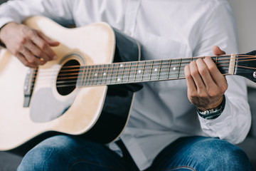 Fototapeta na wymiar cropped image of musician playing acoustic guitar