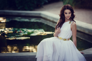 Naklejka premium Young sexy girl with long hair and pretty face in white wedding bride dress
