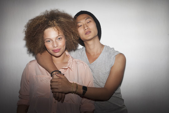 Portrait of smiling couple standing against wall