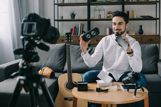 smiling technology blogger recording new vlog about virtual reality headset