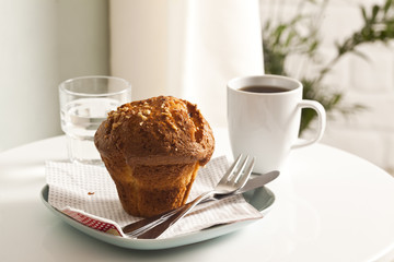 Muffin and coffee on the white table.