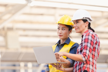 Engineers two woman working on plan building construction with laptop in city