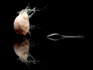 Ei - Egg mit Löffel / with spoon  explodiert / explodes Hintergrund Schwarz / background black 
