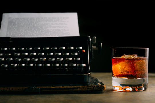 Glass of whiskey and a retro typewriter