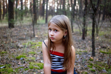Naklejka na ściany i meble Beautiful little girl in the pine forest in summer.