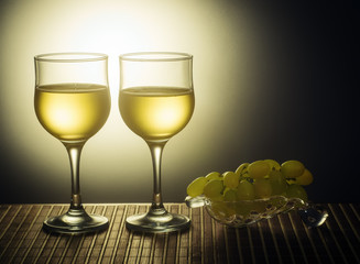 Two glasses of white wine and grapes
