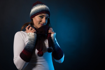 Woman posing before a dark blue background in knitwear