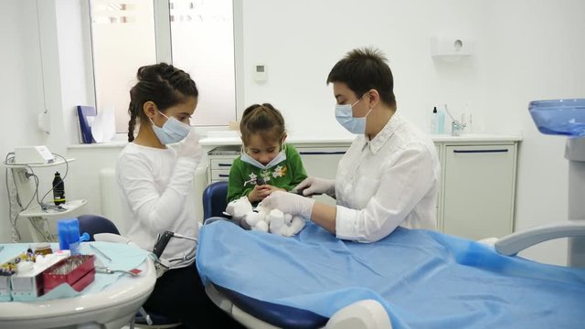 A dentist give to children a dentist mask for play the roles of dentist during a dental check-up