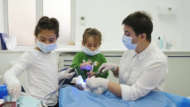 Two little girl play the roles of dentist during a dental check-up