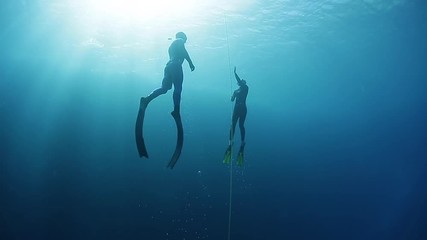 Freedivers ascend along the rope in a sea. Blue Hole, Dahab, Egypt.