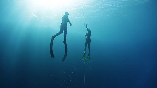 Freedivers ascend along the rope in a sea. Blue Hole, Dahab, Egypt.