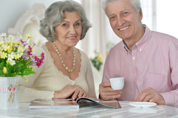 Senior couple drinking tea  and reading magazine
