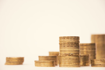 Columns of gold coins of different height on a white background. Savings and business, metal hryvnia. Gold coins.