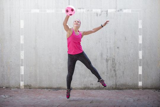 Woman jumping to catch a ball