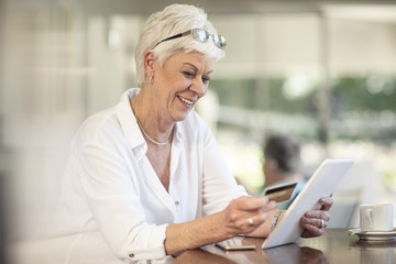 Senior woman shopping online with credit card