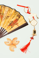 top view of traditional chinese handheld fan with talisman and fortune cookies isolated on white,...