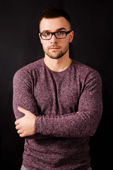 Handsome serious man in glasses isolated on a black background