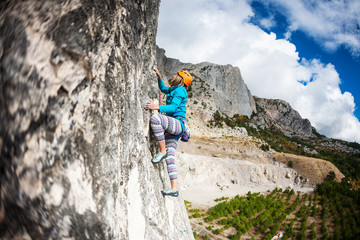 Girl climbs the rock.