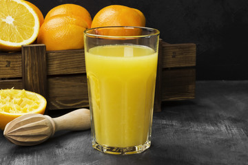 Oranges and fresh orange juice on a black background