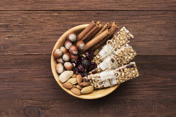 Cereal bars with nuts, berries and cinnamon on a wooden background. Top view. Food background