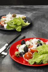 Greek salad feta, cherry tomatoes, olives, cucumbers on a dark background