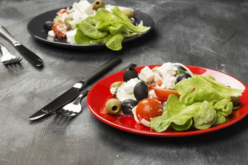 Greek salad feta, cherry tomatoes, olives, cucumbers on a dark background