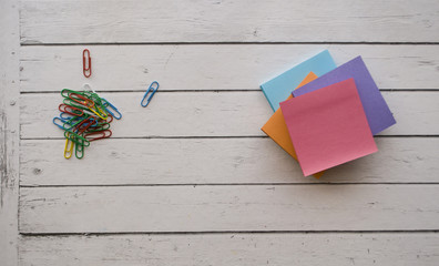 Colorful stationery on white wooden background with text space.