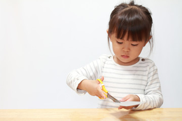 はさみで紙を切る幼児(3歳児)