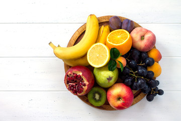 The concept of a healthy diet. Platter fruits and berries - orange, pear, apple, pomegranate,...