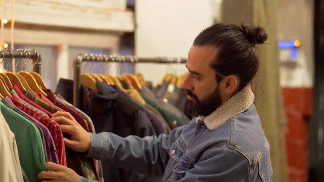 man choosing clothes at vintage clothing store