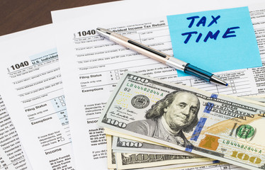 Closeup of Tax Time - written on a sticky notes with money