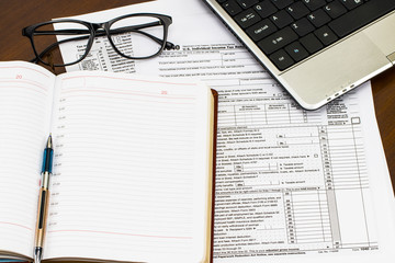 The tax forms with the glasses, money and the pen