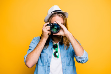 Portrait of guy in hat looking at photo camera, shooting photographs during excursion, making...