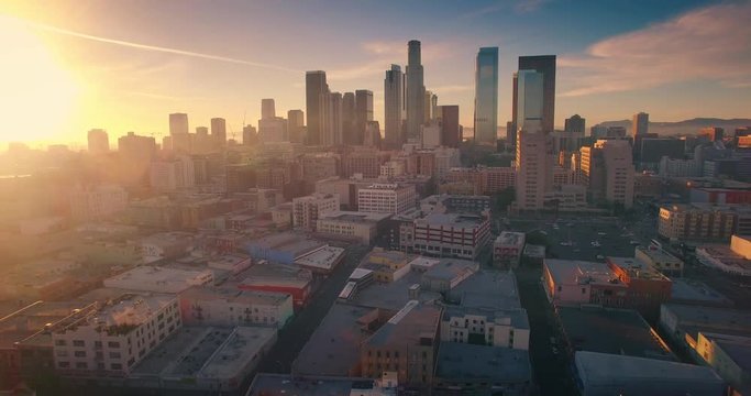 Aerial view city Los Angeles downtown skyline sunset Camera flying backward 4K