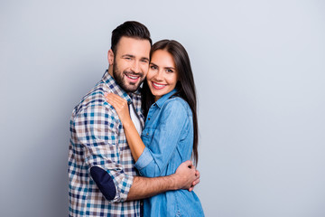 Portrait of  attractive, cute, lovely, cheerful couple with beaming smiles, check to check face, looking at camera, over grey background, 14 february